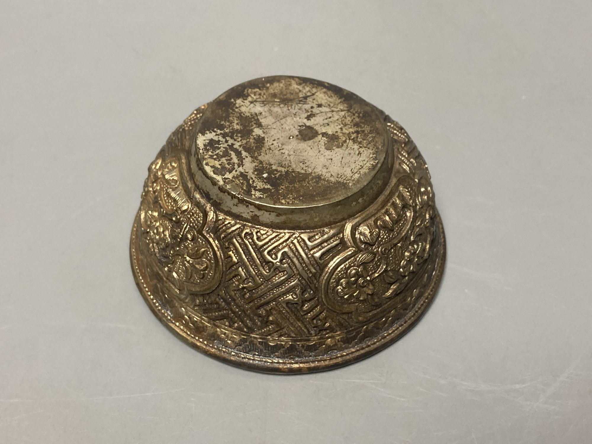 A Sino-Tibetan repousse base metal tea bowl, diameter 8cm